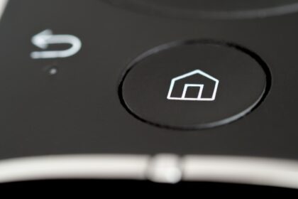 Smart Home Sicherheit im Überblick: Person konfiguriert vernetzte Geräte im Wohnzimmer.