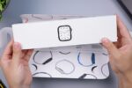 Eine Person mit einer Apple Watch Series 10 am Handgelenk steuert mit dem Display intelligente Lampen und Thermostate in einem modernen Wohnzimmer.