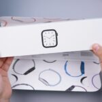 Eine Person mit einer Apple Watch Series 10 am Handgelenk steuert mit dem Display intelligente Lampen und Thermostate in einem modernen Wohnzimmer.