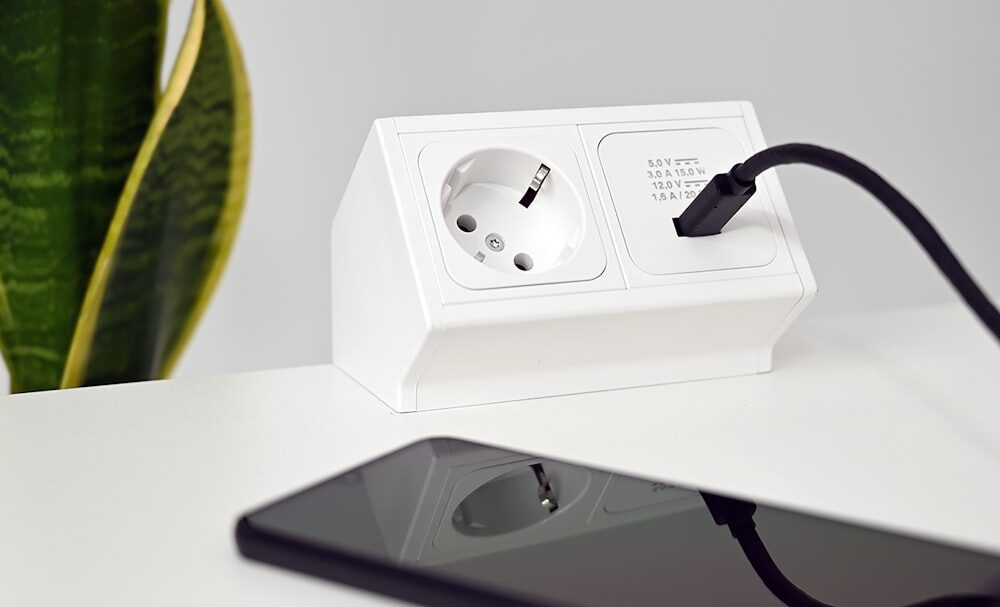 Eine Steckdose mit integriertem WLAN-Stromzähler, die an ein Balkonkraftwerk angeschlossen ist und die Energieerzeugung auf einem Smartphone-Display anzeigt.