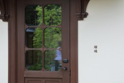 Kleiner Tür- oder Fenstersensor auf weißem Hintergrund, daneben ein Smartphone, das eine Benachrichtigung über eine geöffnete Haustür anzeigt.