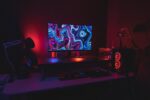 Ein modernes Smart-Home-Setup mit intelligenten Geräten wie einem Roboterstaubsauger, smarten Lampen und einem Lautsprecher auf einem hellen Holztisch.