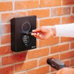 Intelligentes Türschloss mit Display, das den Energieverbrauch der Heizung anzeigt, während es per Fingerabdruck entriegelt wird.