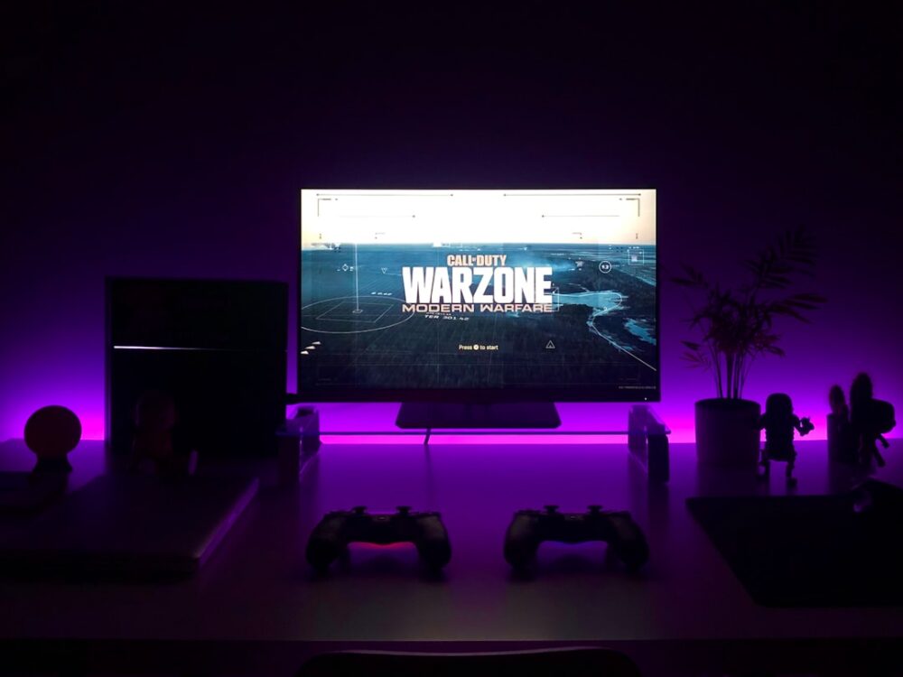 Ein schlanker, unscheinbarer Infrarot-Sender liegt dezent auf einem Sideboard, während im Hintergrund ein Fernseher und eine Soundbar ohne sichtbare Kabel oder Geräteharmonie zu sehen sind – smarte Technik, die im Wohnraum verschwindet.